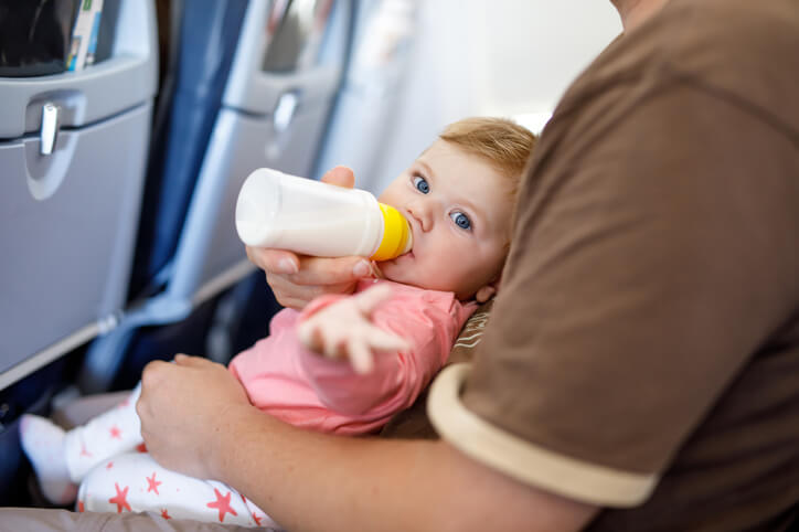 Dad holding his baby daughter during flight on airplane