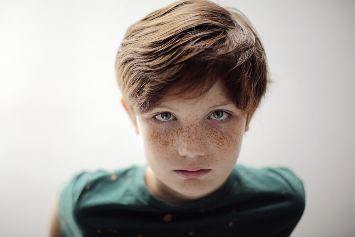 Portrait of redhead boy with freckles and green eyes