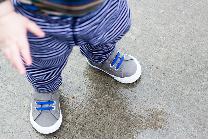 Baby boy shoes on wet concrete.