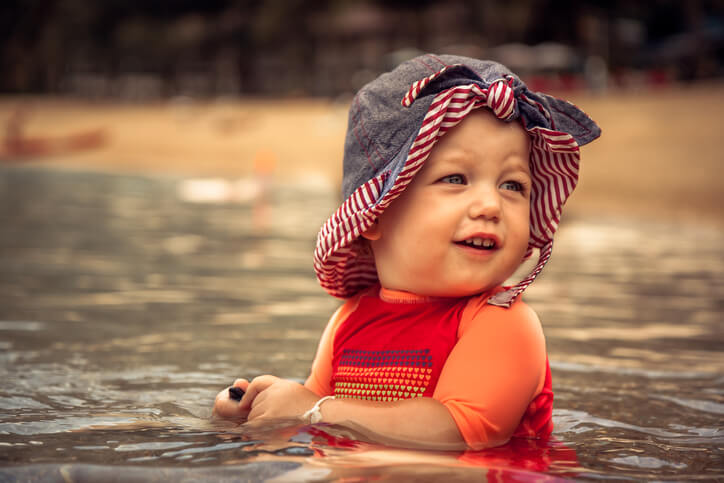 Cute cheerful child girl enjoy swimming in sea during beach holidays