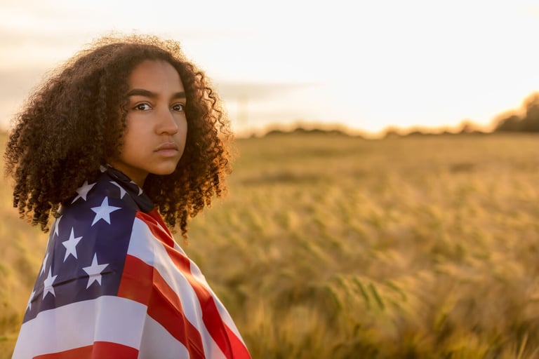 Sad depressed mixed race African American girl teenager female young woman in a field of wheat