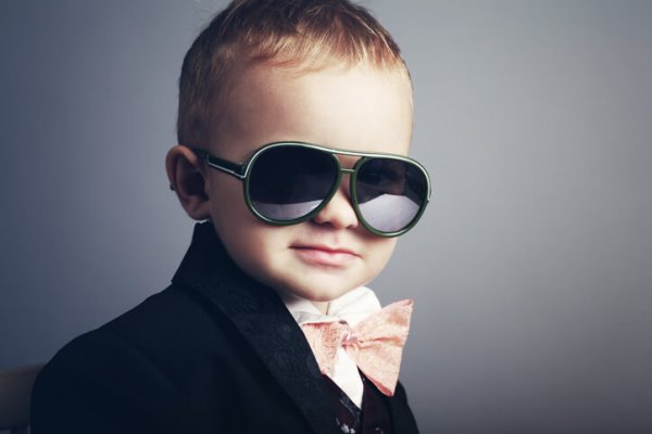 Young boy dressed as a gentleman with sunglasses