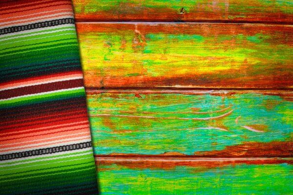 Traditional mexican serape (blanket) on a vibrantly colored rustic wood background