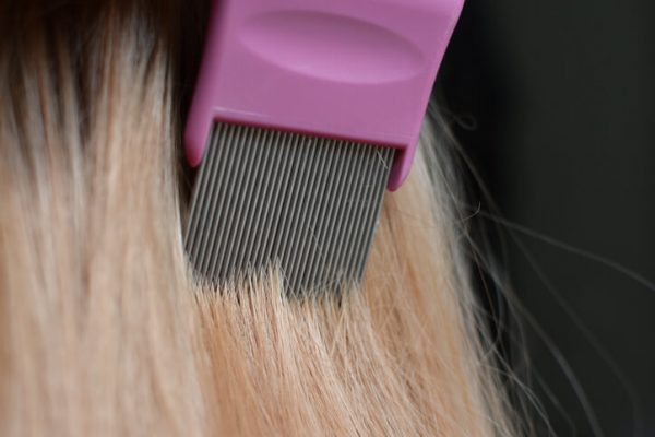 Combing blond hair with a lice comb