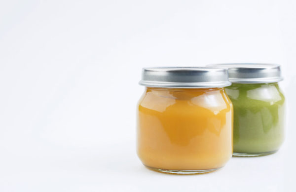 Baby vegetable or fruit puree in a glass jar on a white background