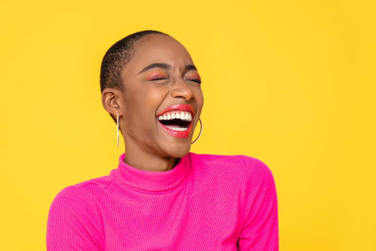 Happy optimistic African American woman in colorful pink clothes