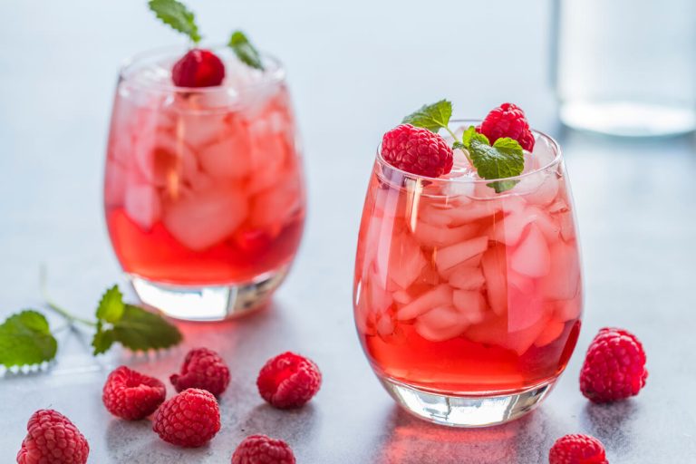 Refreshing red drink with fresh raspberries and crushed ice