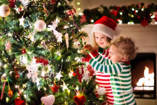 Kids decorating Christmas tree in beautiful living room