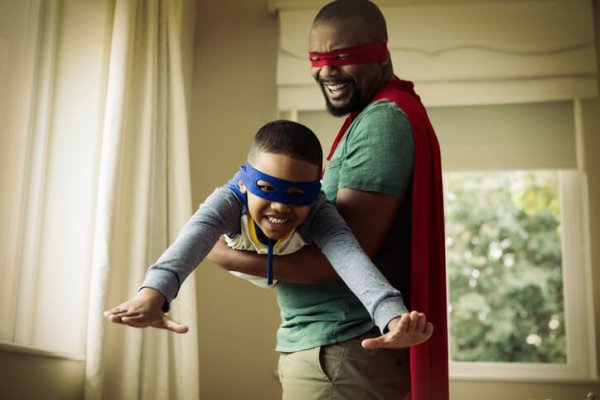 a dad playing superheroes with his son