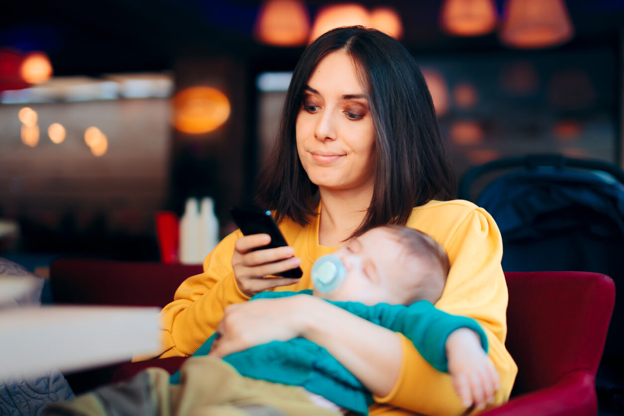 Bored Nanny Checking Smartphone While Baby is Sleeping