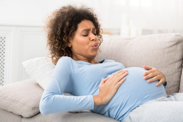 Expectant woman having contractions and doing breathing exercises