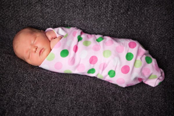Color Image of Sleeping Newborn Baby Girl Wrapped in Swaddle Blanket