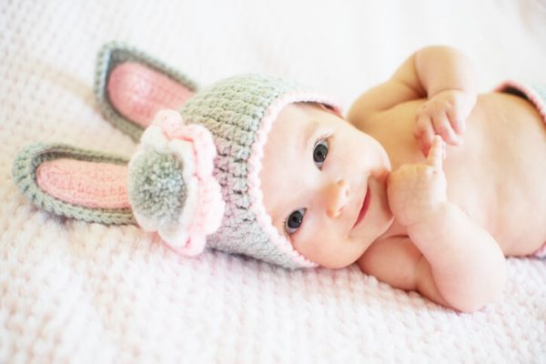 A cute baby girl in a Easter bunny hat.