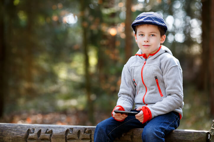 Portrait of little English boy sitting on a bench outdoors