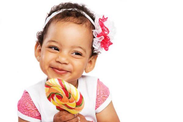 Cheerful little girl with a big lollipop