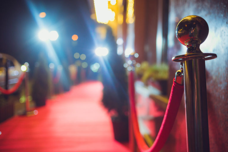 Long red carpet between rope barriers with stair at the end