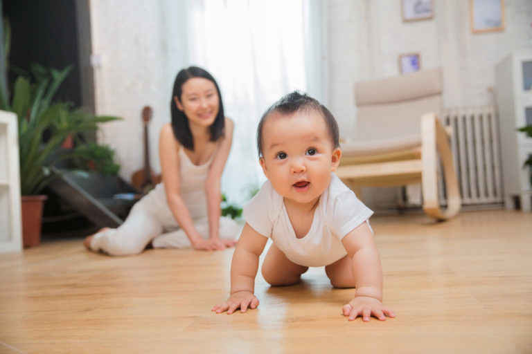 a baby crawling on the floor of a house
