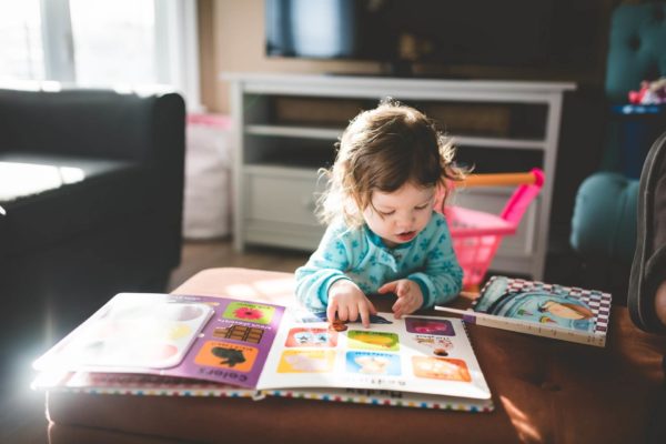 a toddler reading some picture books