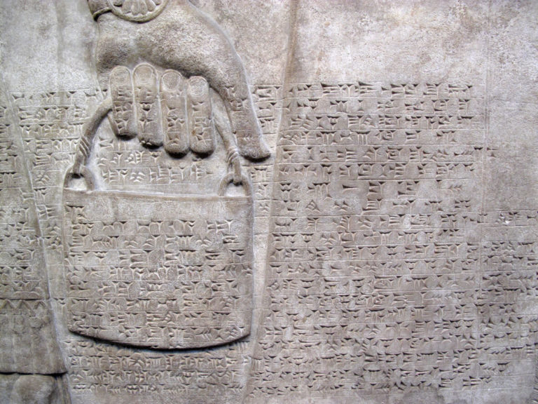 Assyrian relief 865-860 BC, showing cuniform script, and a royal helper carrying a bucket