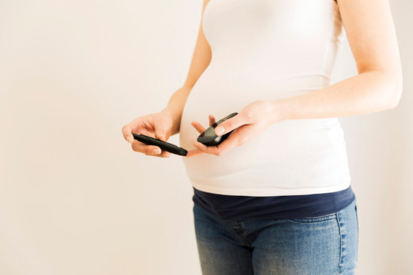 Pregnant woman checking blood sugar level