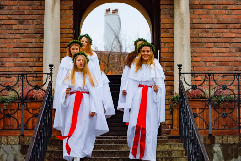 A school group in Liljeholmen performs a traditional Santa Lucia celebration with song on the steps of school