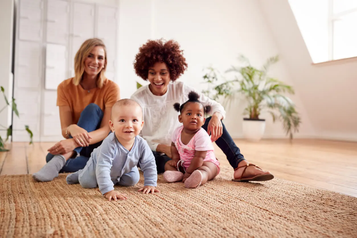 two mothers and their babies playing on the floor